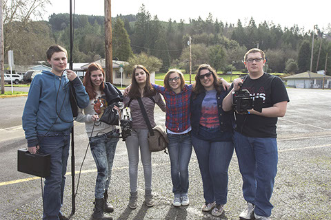 a group of teens holding camera gear smiling