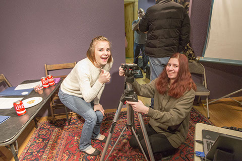 2 girls smiling with camera equipment